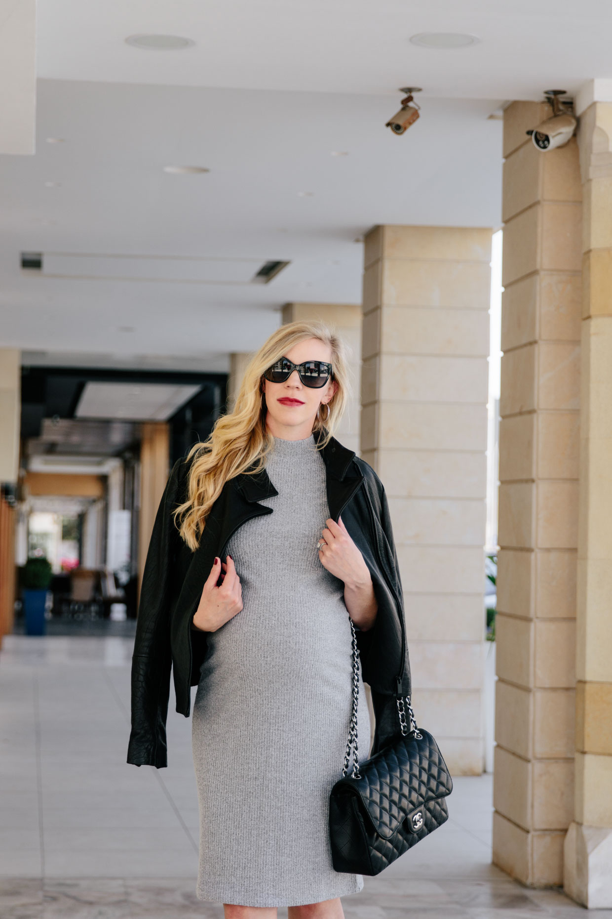 Meagan Brandon fashion blogger of Meagan's Moda shows what to wear in third  trimester, stylish maternity outfit with gray sweater dress and black  leather jacket - Meagan's Moda