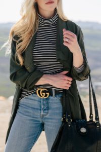 transitional spring outfit with olive jacket and striped turtleneck