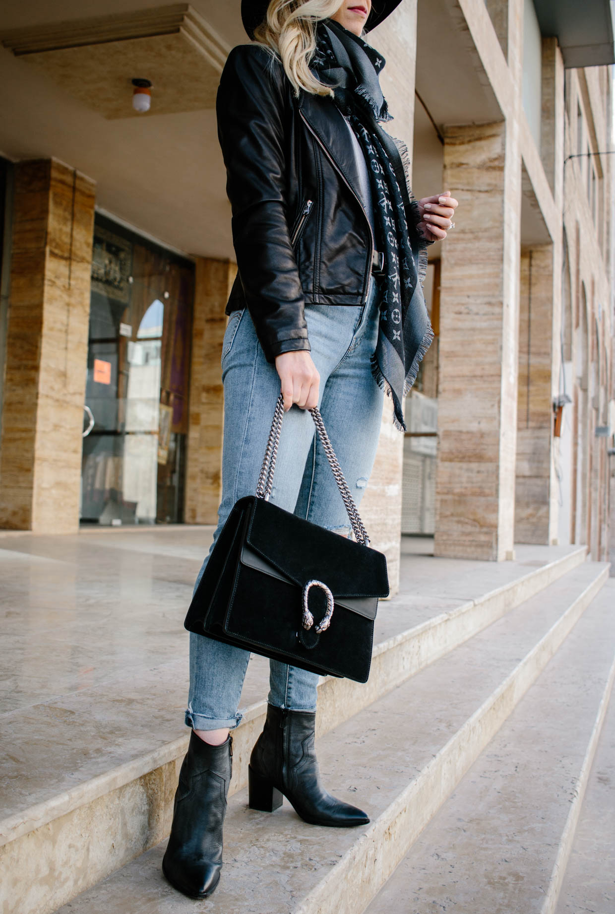 Meagan Brandon fashion blogger of Meagan's Moda wears Louis Vuitton black  shine shawl with black leather jacket, gray jeans and black moto boots for  chic black and gray outfit - Meagan's Moda