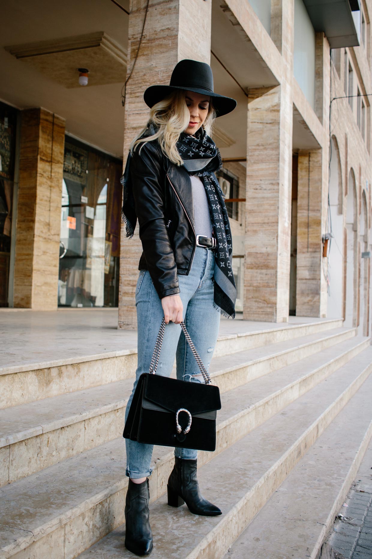 Elegant lady with hat, scarf, boots and Louis Vuitton bag