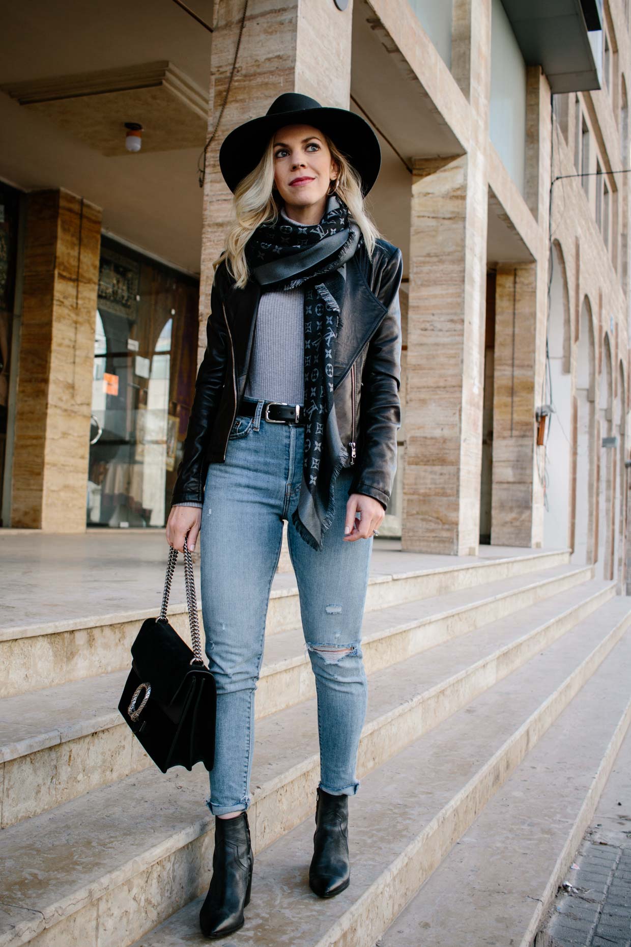 Meagan Brandon fashion blogger of Meagan's Moda wears Louis Vuitton black  shine shawl with black leather jacket, gray jeans and black moto boots for  chic black and gray outfit - Meagan's Moda