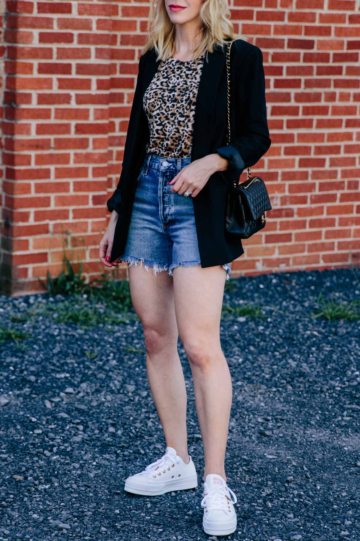 Meagan Brandon fashion blogger of Meagan's Moda wears an oversized black  blazer with leopard print tee, high waist denim shorts and white sneakers  for casual chic blazer outfit - Meagan's Moda