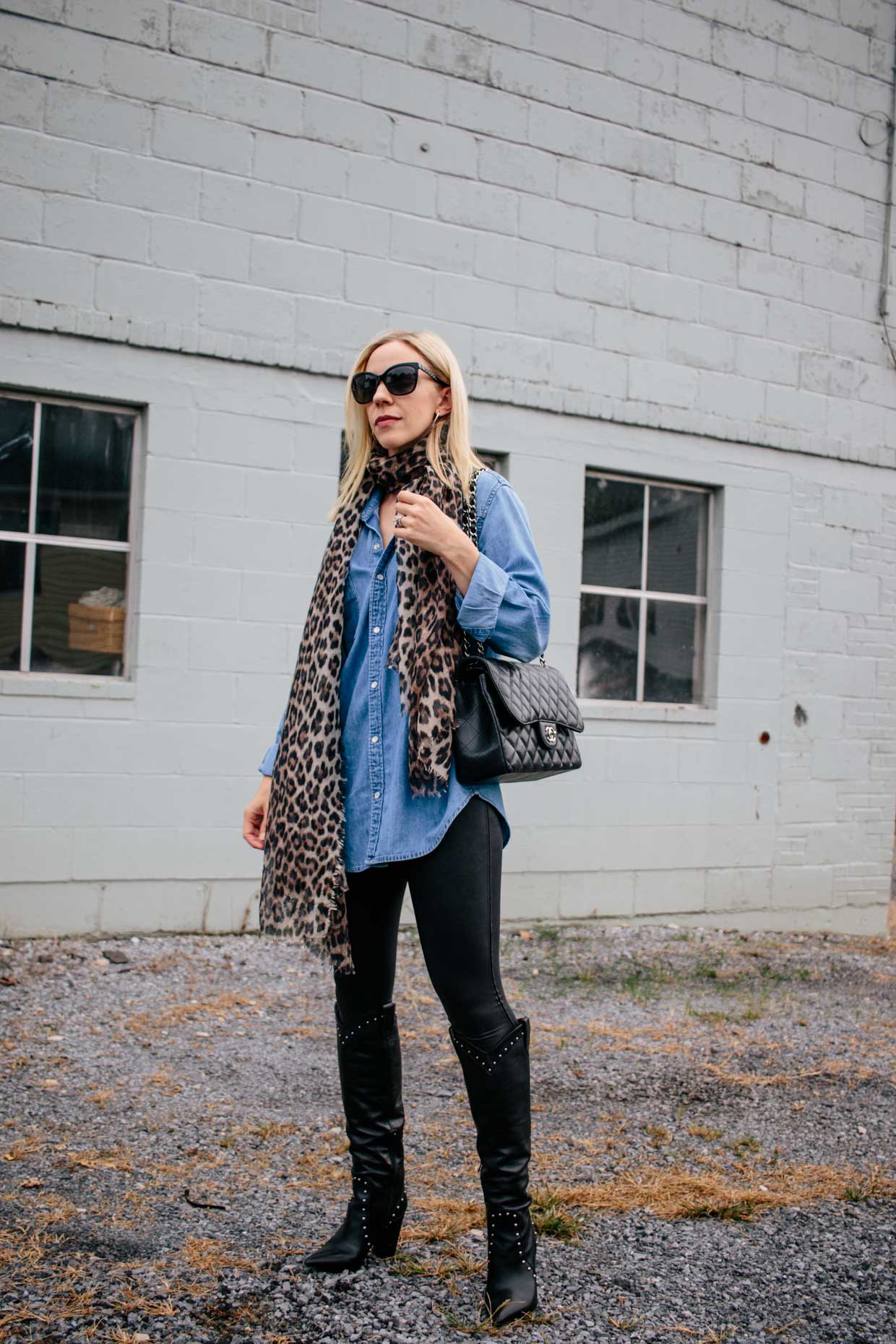 Meagan Brandon fashion blogger of Meagan's Moda shows how to style Spanx  faux leather leggings with oversized long denim tunic shirt and leopard  print scarf - Meagan's Moda