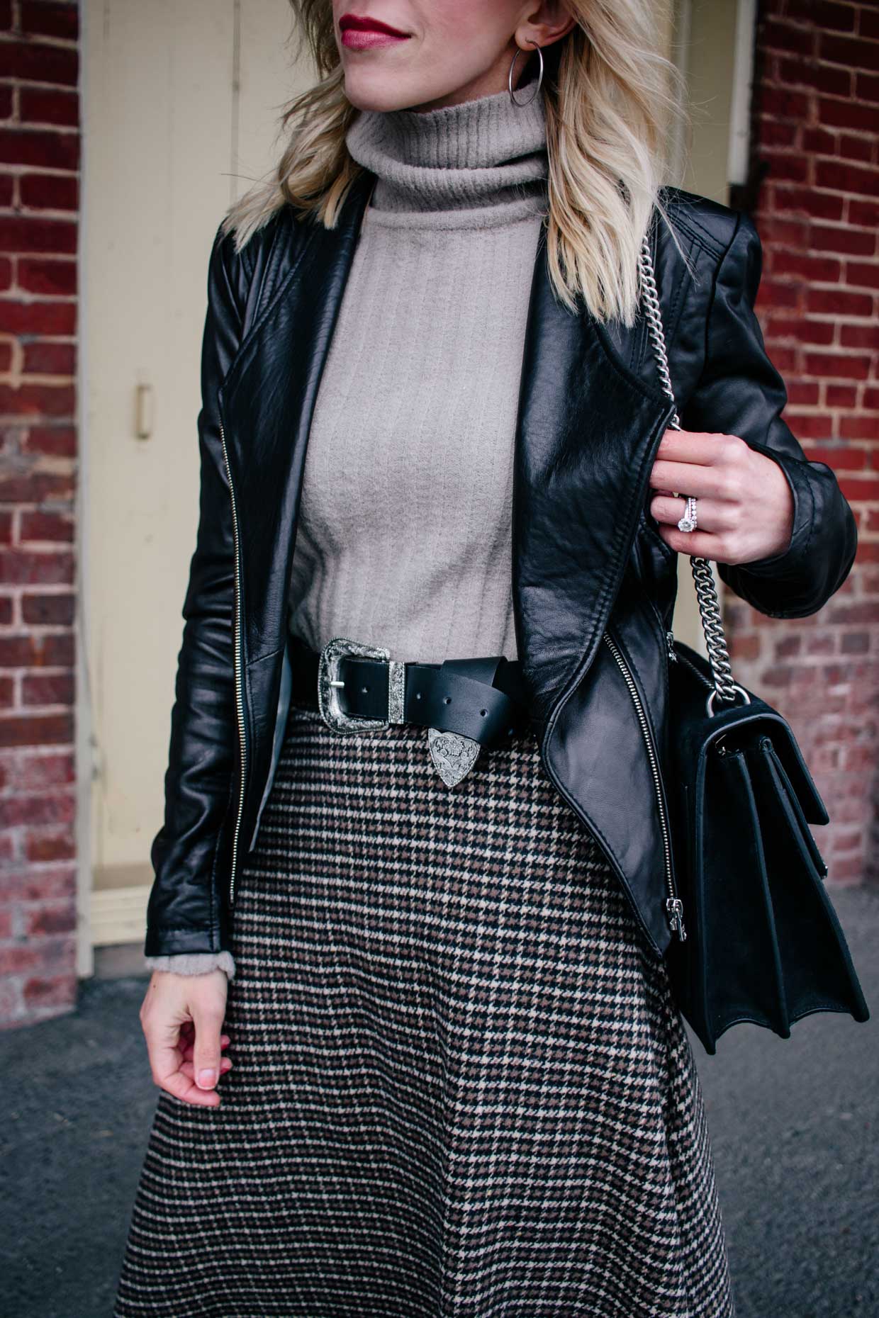 Meagan Brandon fashion blogger of Meagan's Moda shows how to wear a western  belt with leather moto jacket, turtleneck sweater and houndstooth midi  skirt - Meagan's Moda