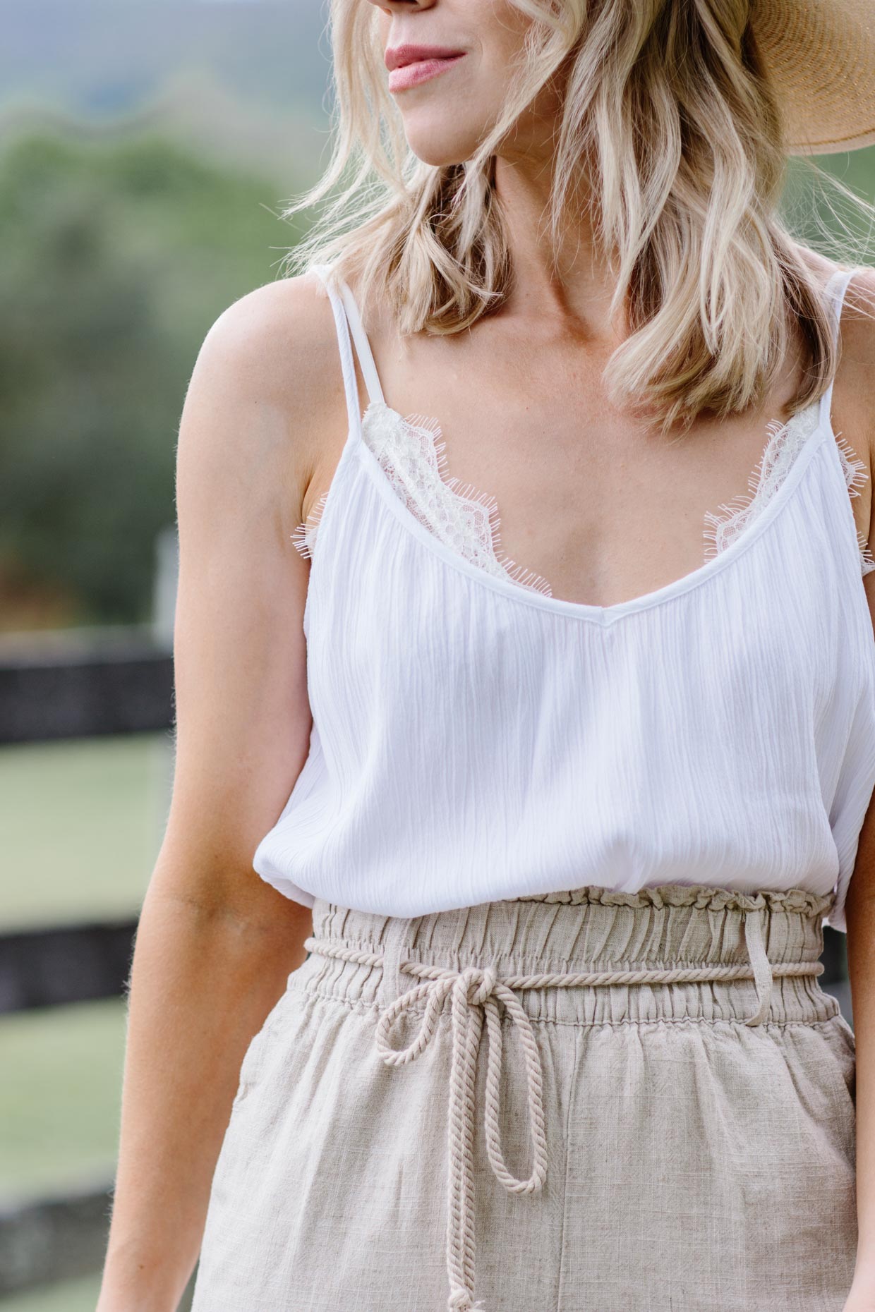 https://www.meagansmoda.com/wp-content/uploads/2020/05/Meagan-Brandon-fashion-blogger-of-Meagans-Moda-wears-white-camisole-with-white-lace-bralette-for-summer-bralette-outfit-idea.jpg