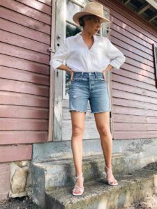Meagan Brandon fashion blogger of Meagan's Moda wears Levi's 501 mid length denim shorts with white linen shirt, most flattering denim shorts