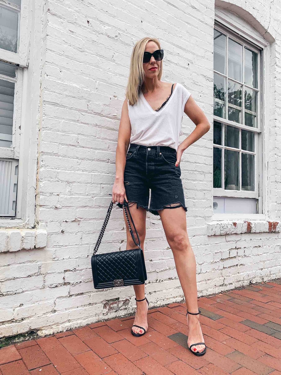 Meagan Brandon fashion blogger of Meagan's Moda wears black Levi's 501 distressed  denim shorts with white tank and heels - Meagan's Moda