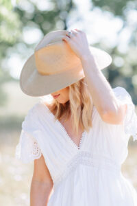 Meagan Brandon fashion blogger of Meagan's Moda wears Janessa Leone Francis straw hat with white dress