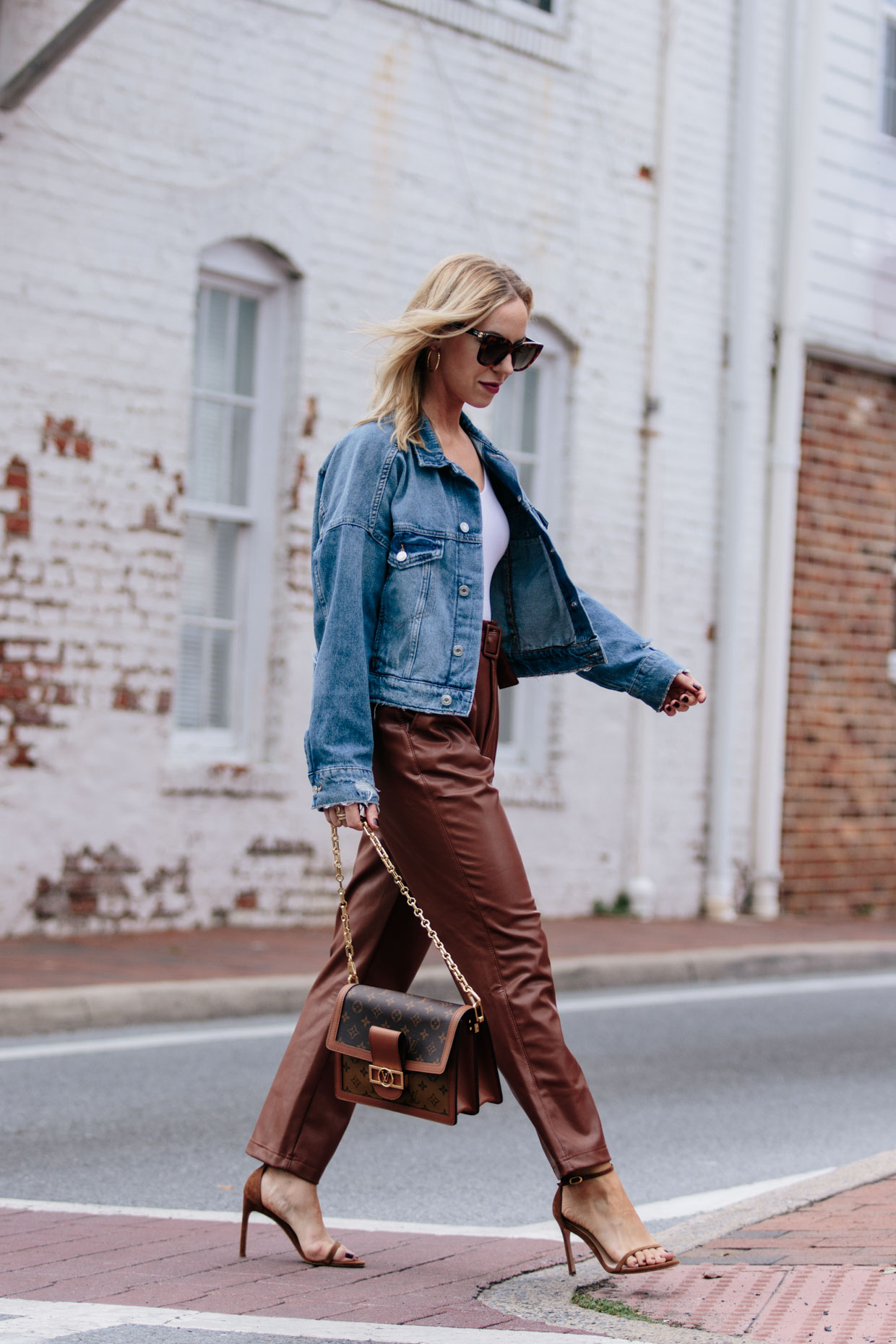 Meagan Brandon fashion blogger of Meagan's Moda wears boxy cropped denim jacket with brown faux leather pants and Louis Vuitton Dauphine bag