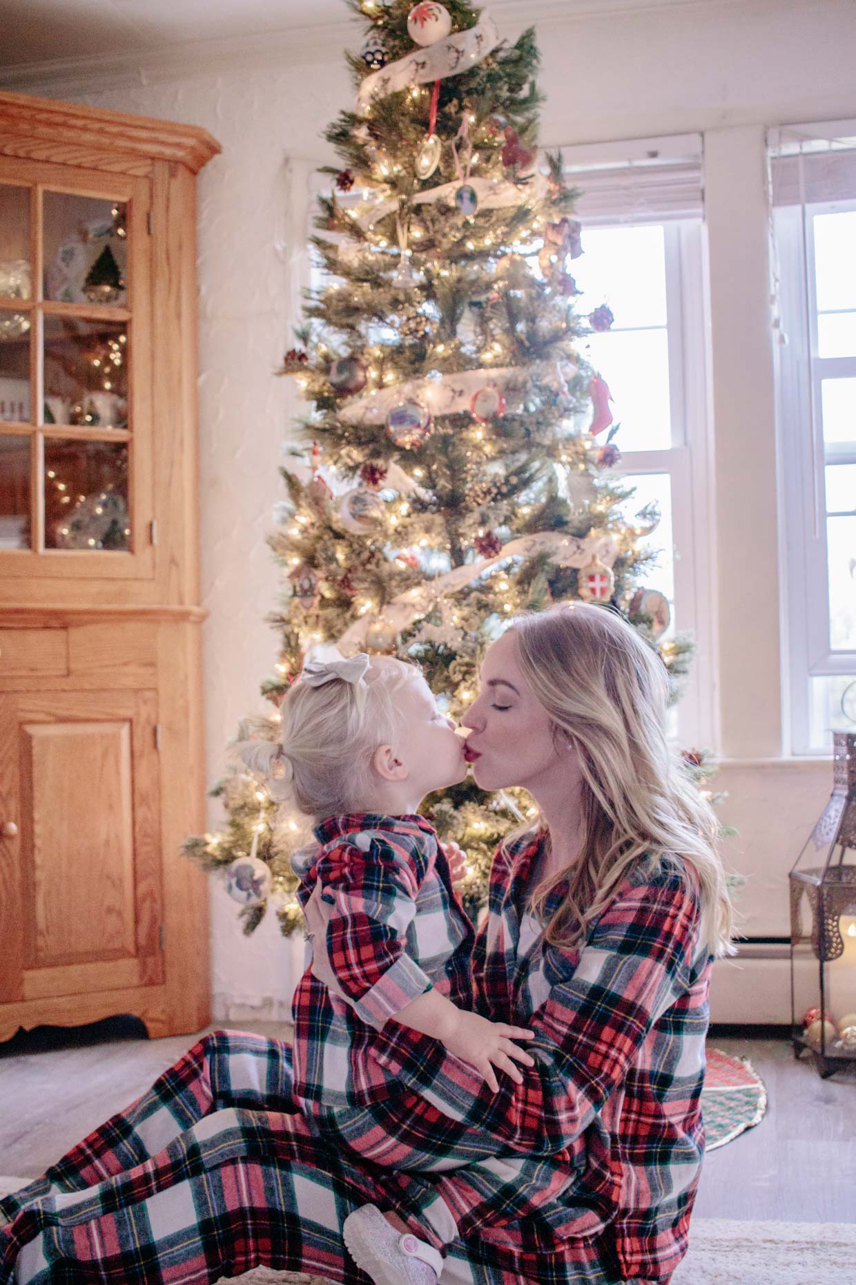 Meagan Brandon fashion blogger of Meagan's Moda wears matching Christmas family pajamas from Old Navy with toddler daughter tartan plaid family pajamas