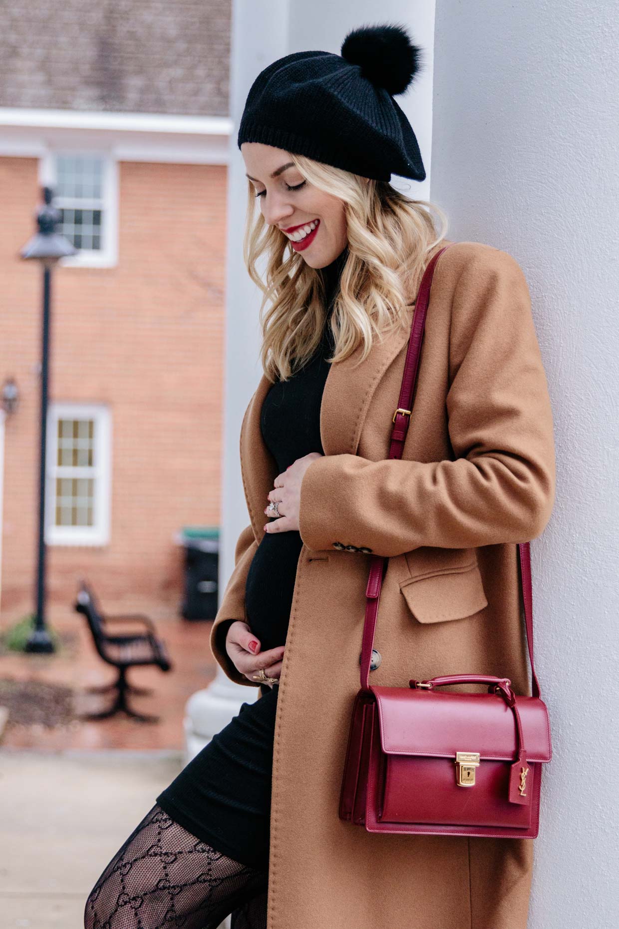 Meagan Brandon fashion blogger of Meagan's Moda wears camel coat with pom  hat and black turtleneck dress, Gucci tights and red YSL bag maternity  outfit - Meagan's Moda