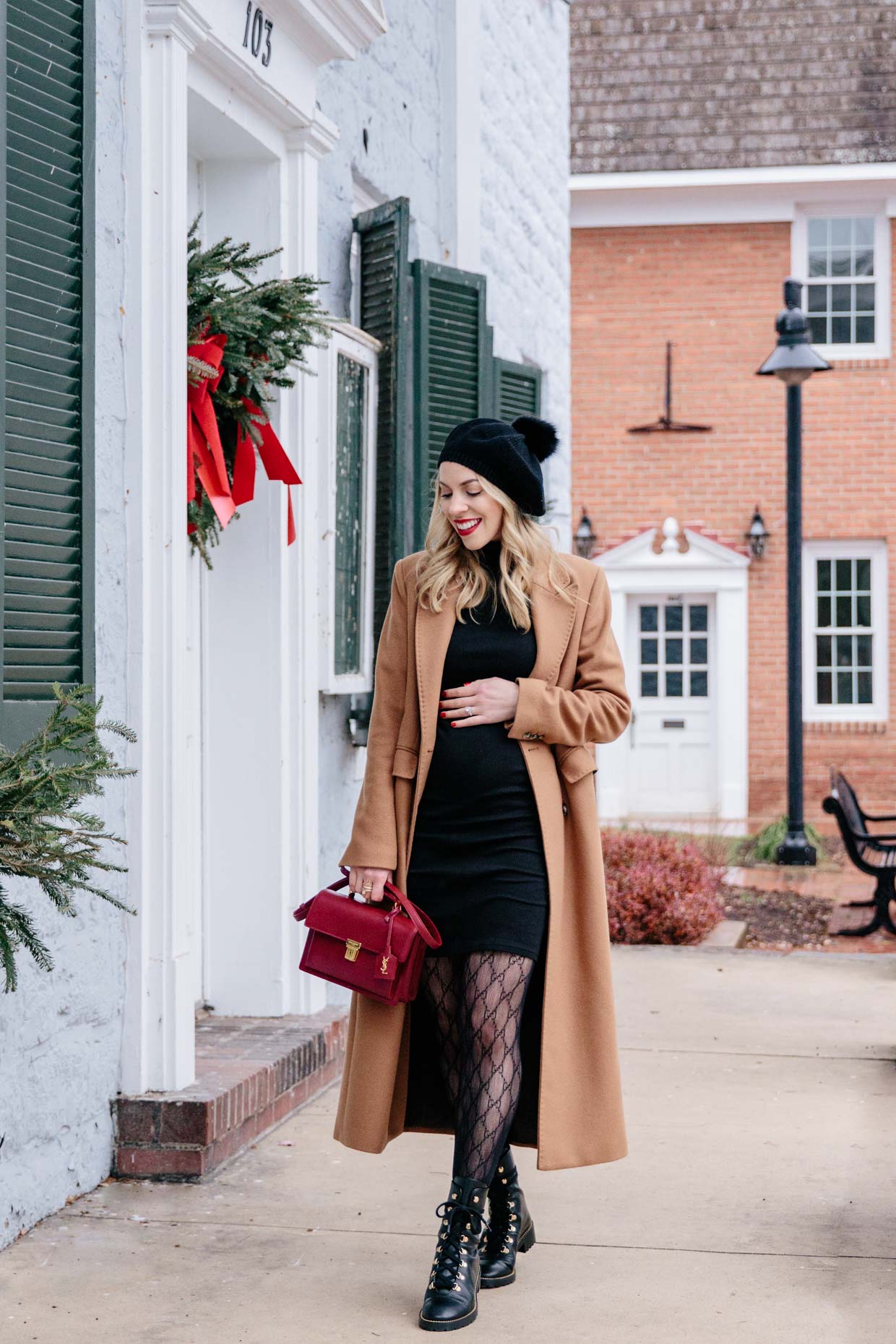 Meagan Brandon fashion blogger of Meagan's Moda wears double breasted camel coat over fitted black turtleneck dress with Gucci tights and combat boots