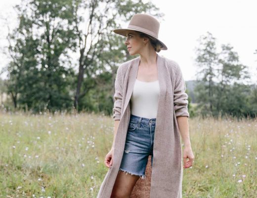 Meagan Brandon style influencer shows how to wear a duster cardigan for early fall with denim shorts and sandals