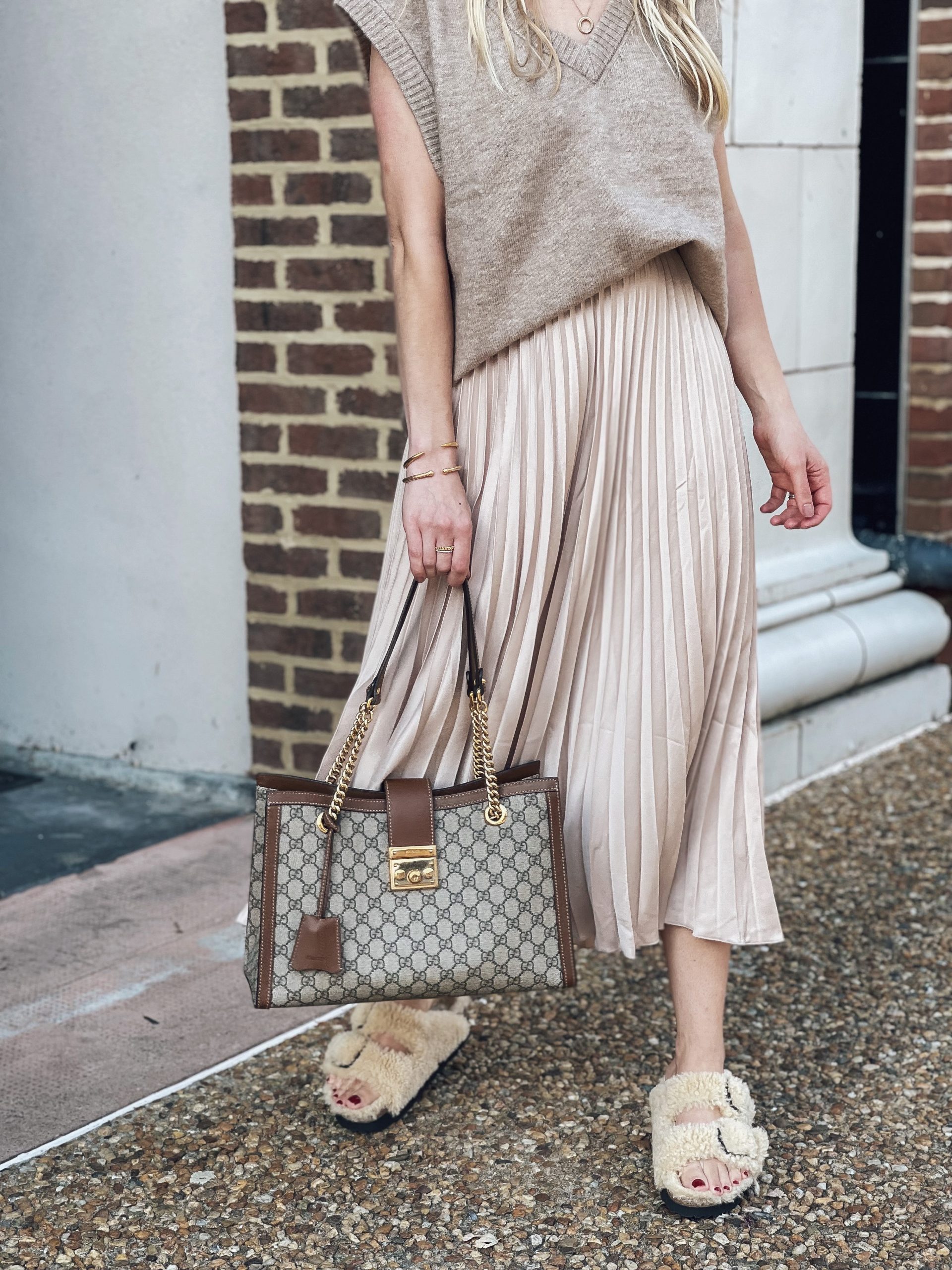 Meagan Brandon of Meagan's Moda shows how to wear fuzzy Birkenstock teddy shearling Arizona slide sandals for fall with pleated midi skirt