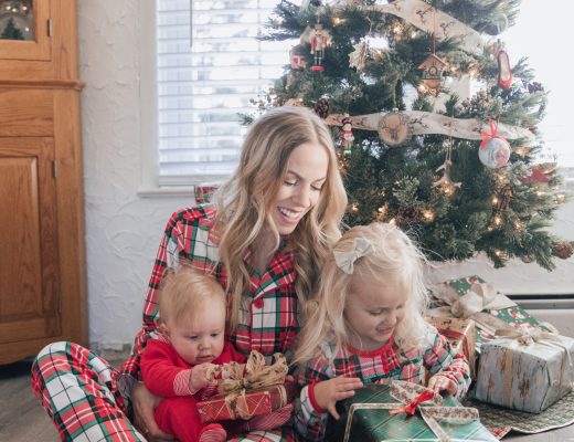 Meagan Brandon of Meagan's Moda wears matching plaid Christmas pajamas with toddler and baby girl